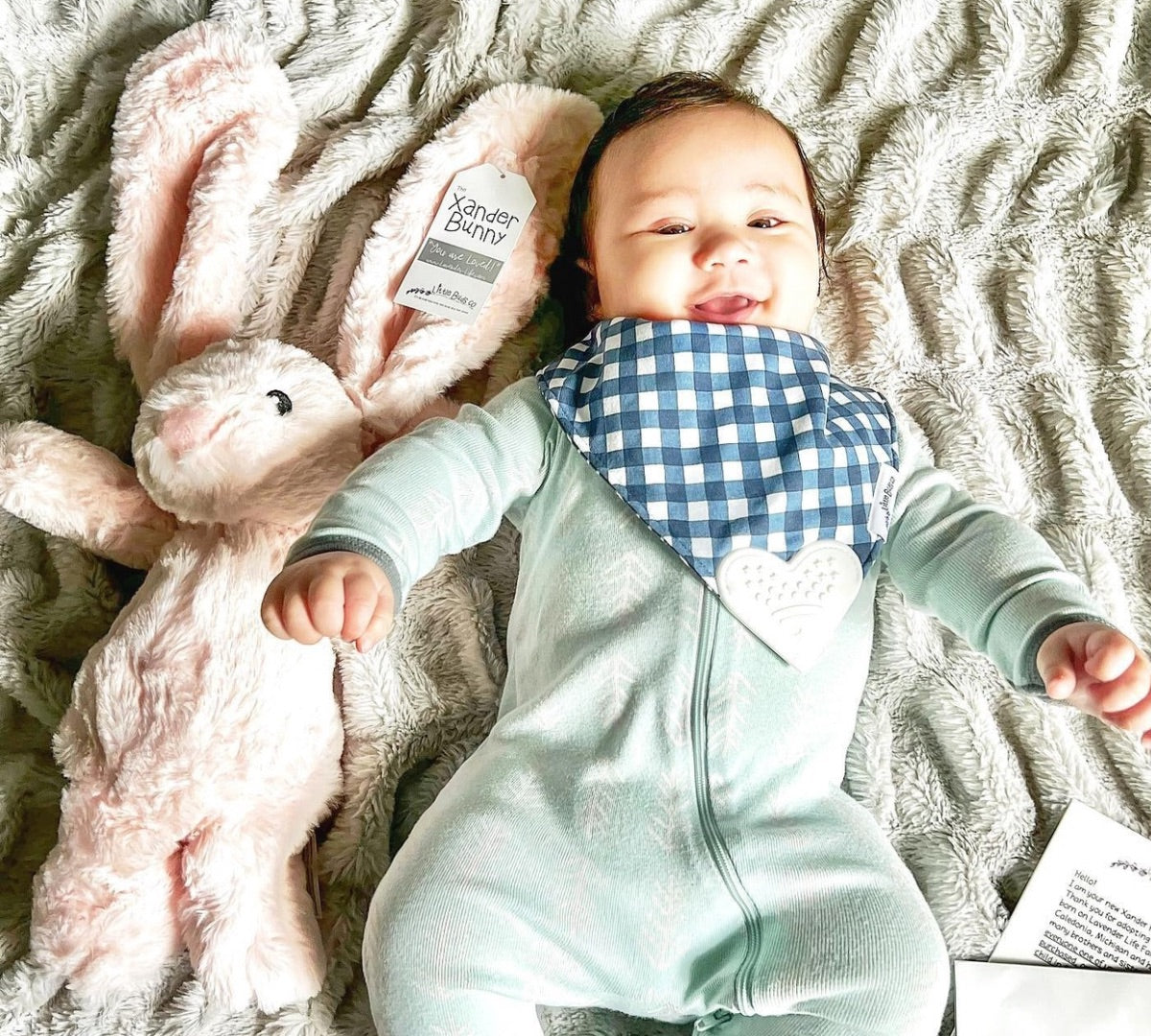 Baby laying next to Pink Xander Bunny