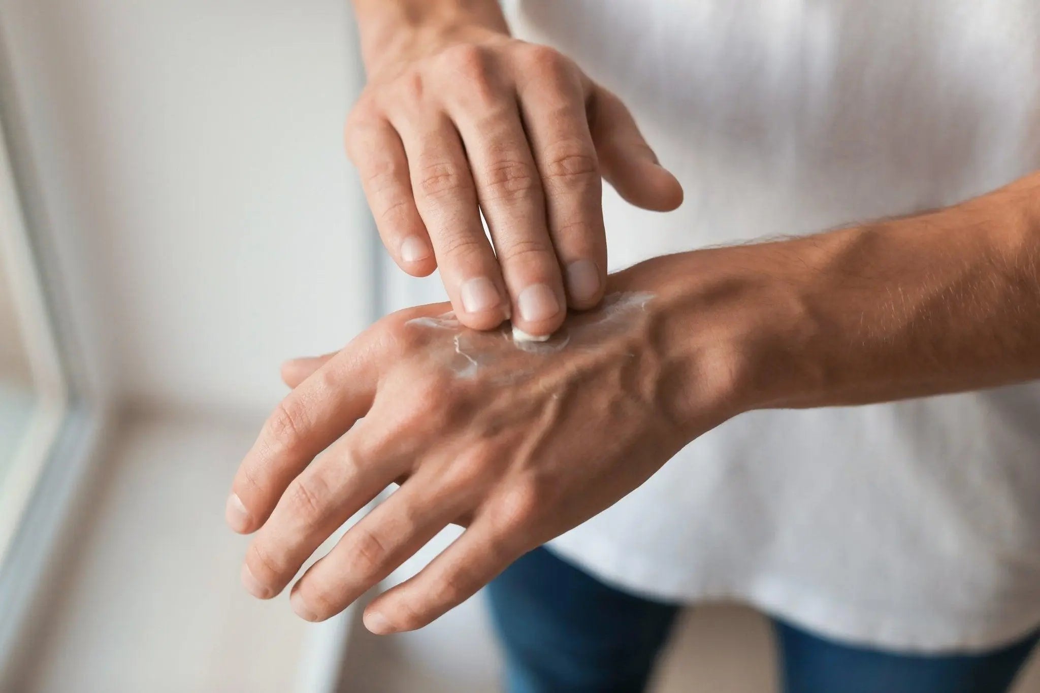 woman applying cream to back of her hand