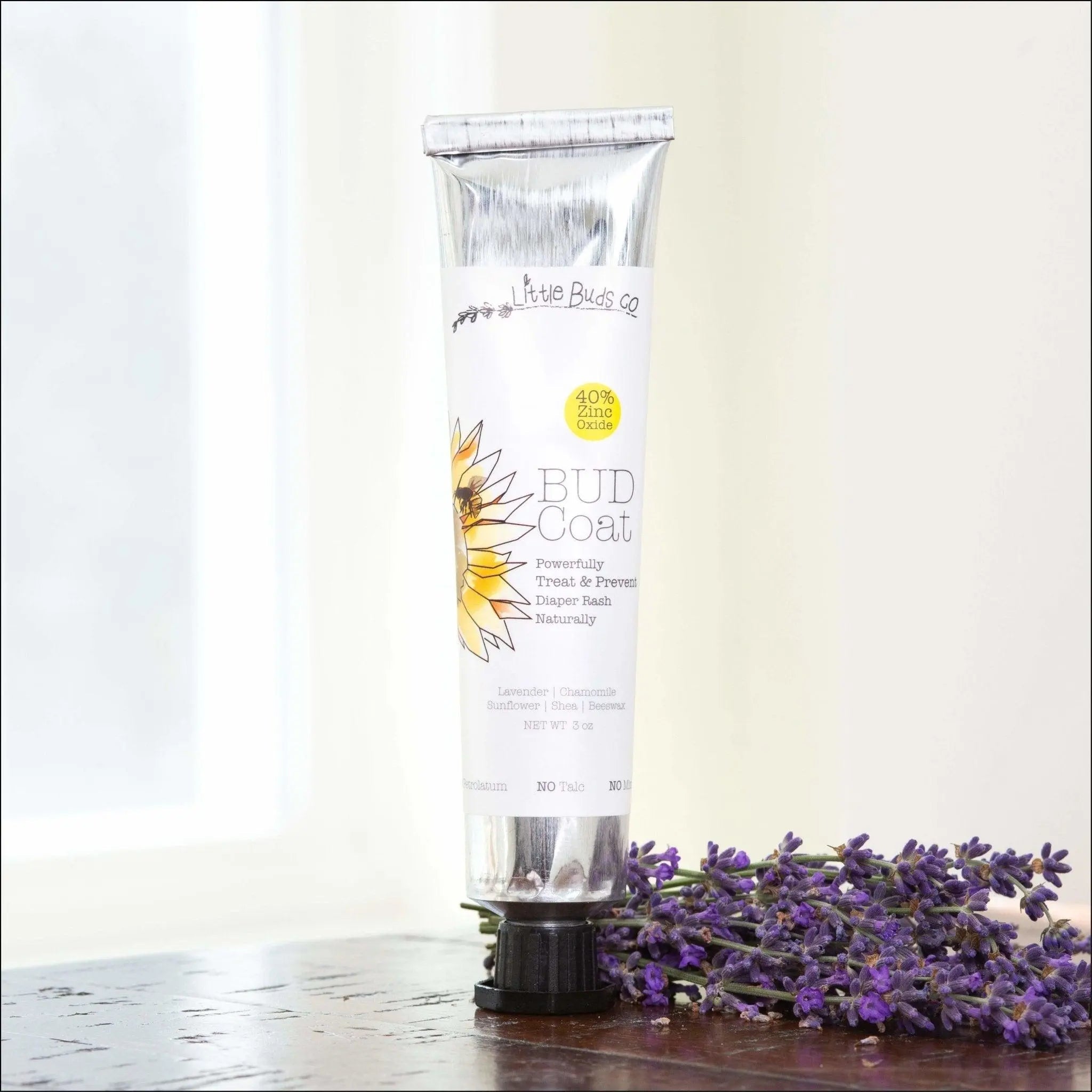 Aluminum tube of Bud Coat baby bottom cream on a table with lavender next to it