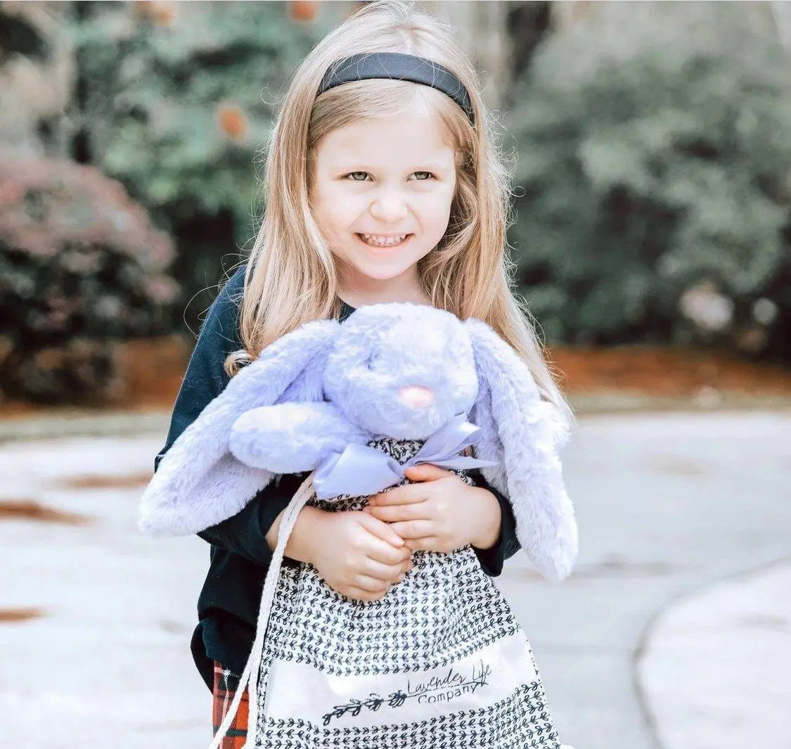 girl with xander bunny in purple holding standing on a street