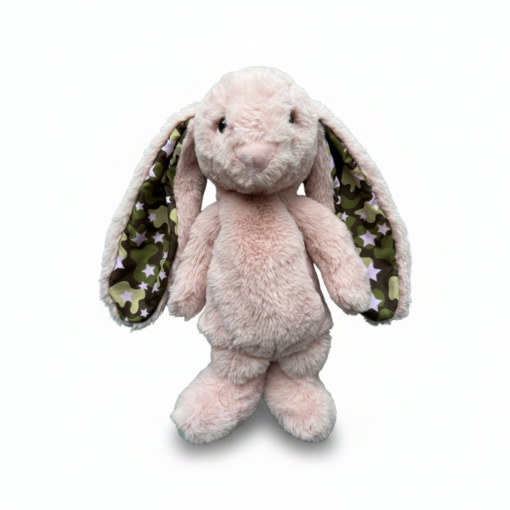 Plush bunny toy with patterned ears on a green cushion