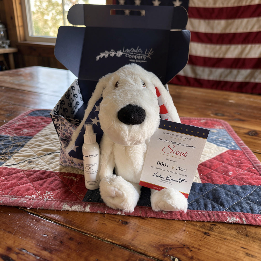 Stuffed dog toy with a bottle and tag on a wooden table with a flag in the background